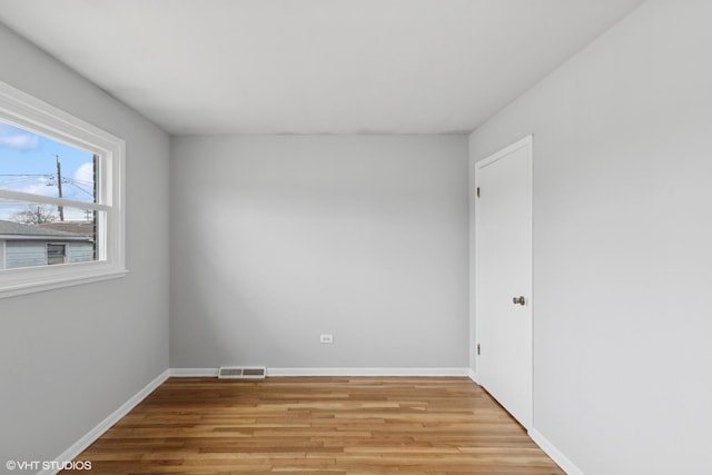 spare room with light wood-style flooring, baseboards, and visible vents