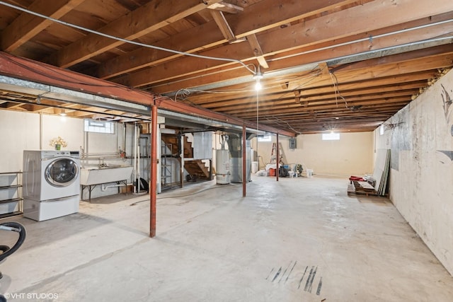 below grade area featuring a sink, washer / clothes dryer, and water heater