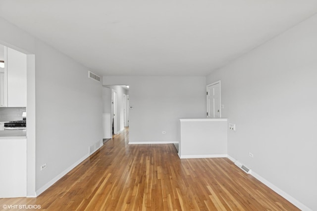 unfurnished living room with light wood-style floors, visible vents, and baseboards