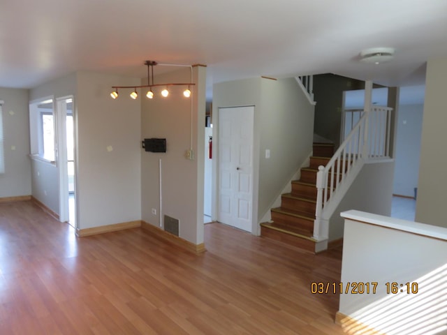 interior space featuring visible vents, stairway, baseboards, and light wood-style floors