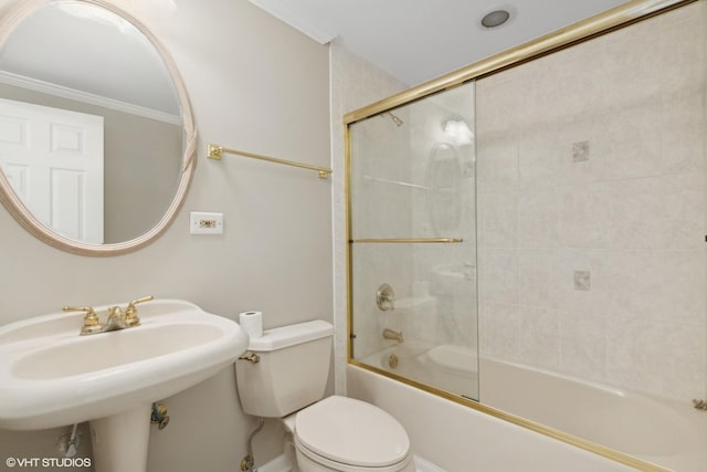 bathroom with toilet, enclosed tub / shower combo, ornamental molding, and a sink