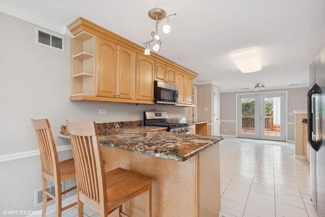 kitchen featuring appliances with stainless steel finishes, light brown cabinetry, a peninsula, baseboards, and french doors