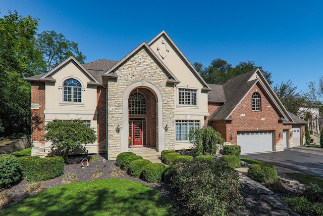 view of front of home with brick siding, stucco siding, driveway, and a garage