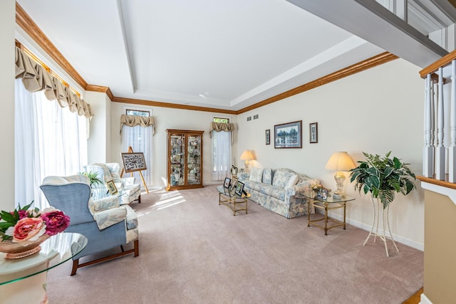 living room with visible vents, baseboards, carpet floors, a tray ceiling, and ornamental molding