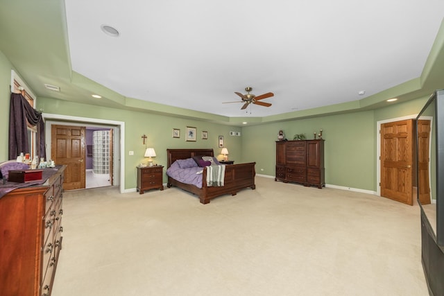 bedroom featuring recessed lighting, baseboards, light carpet, and a raised ceiling