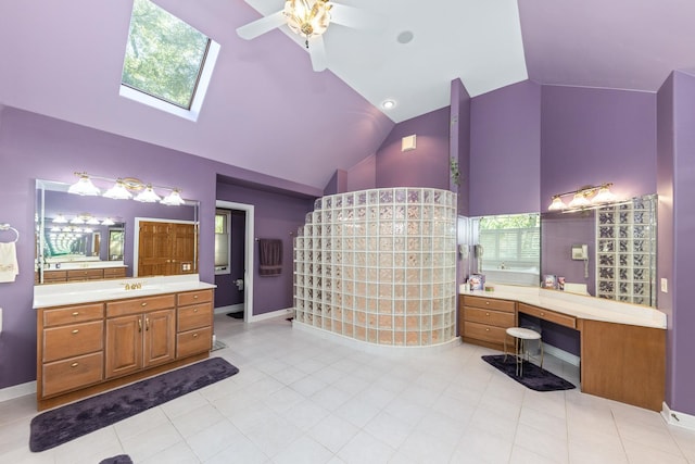 full bath featuring baseboards, high vaulted ceiling, two vanities, a sink, and a walk in shower