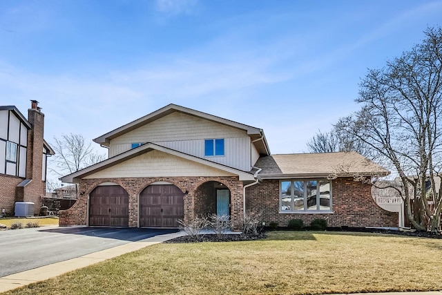 view of front of house featuring brick siding, aphalt driveway, a front yard, cooling unit, and a garage