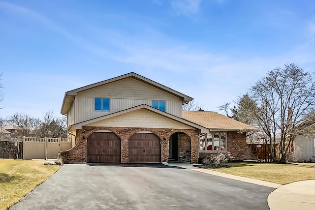 view of front facade featuring aphalt driveway, brick siding, a front lawn, and fence