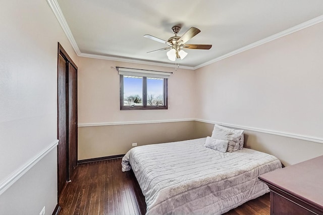 bedroom featuring baseboards, ceiling fan, ornamental molding, hardwood / wood-style floors, and a closet