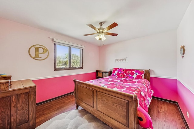 bedroom featuring ceiling fan, baseboards, and wood finished floors