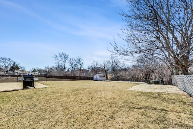 view of yard featuring a patio area, a shed, an outdoor structure, and a fenced backyard