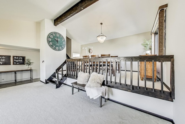 sitting room featuring stairs, baseboards, vaulted ceiling with beams, and carpet flooring