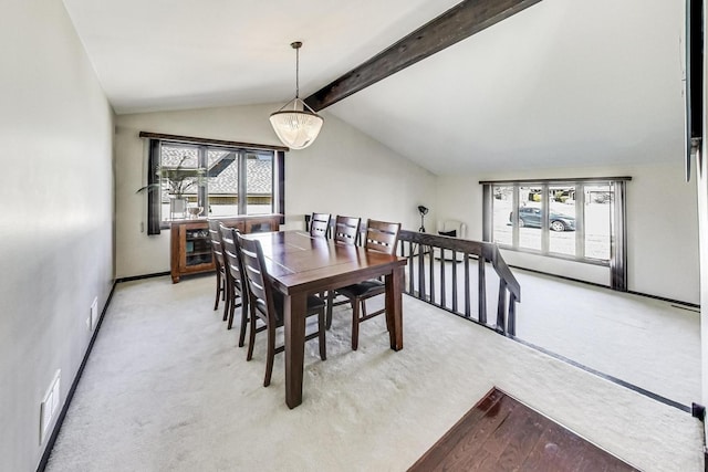 dining room with lofted ceiling with beams, plenty of natural light, visible vents, and light carpet