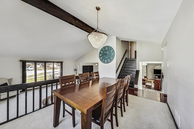 dining room featuring stairway, baseboards, an inviting chandelier, vaulted ceiling with beams, and light colored carpet