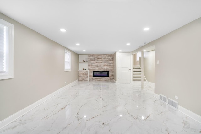 unfurnished living room featuring stairway, baseboards, recessed lighting, a fireplace, and marble finish floor