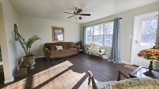 living room with dark wood-style floors, baseboards, and ceiling fan