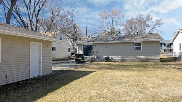 rear view of property with an outbuilding, a lawn, central AC unit, and a patio