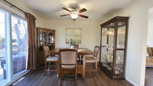 dining space featuring dark wood finished floors, a ceiling fan, visible vents, and baseboards