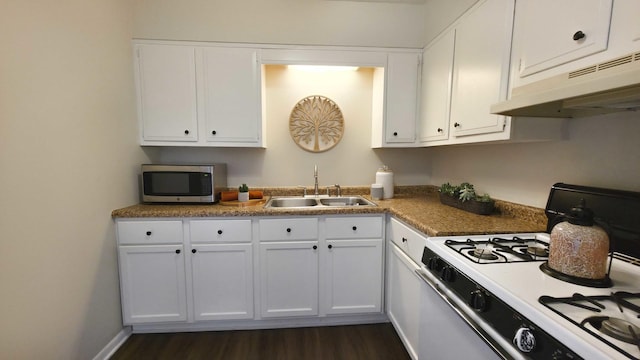 kitchen featuring white gas stove, a sink, white cabinets, under cabinet range hood, and stainless steel microwave