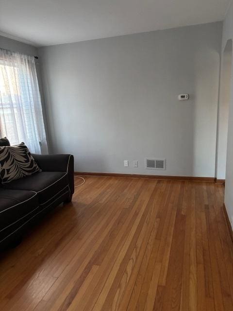 unfurnished living room featuring visible vents, light wood-style flooring, and baseboards