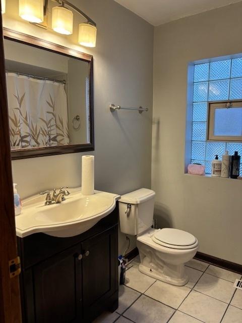 full bathroom with tile patterned floors, baseboards, toilet, and vanity