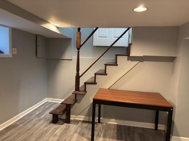 staircase featuring baseboards and wood finished floors