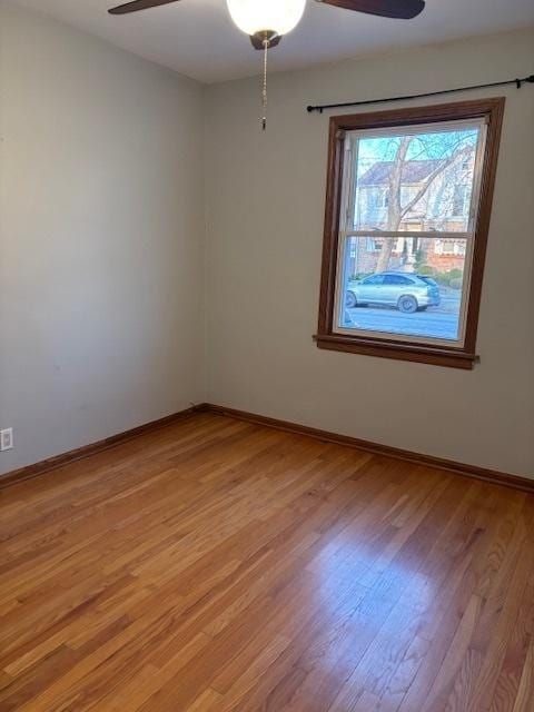 unfurnished room featuring baseboards, light wood-style flooring, and a ceiling fan