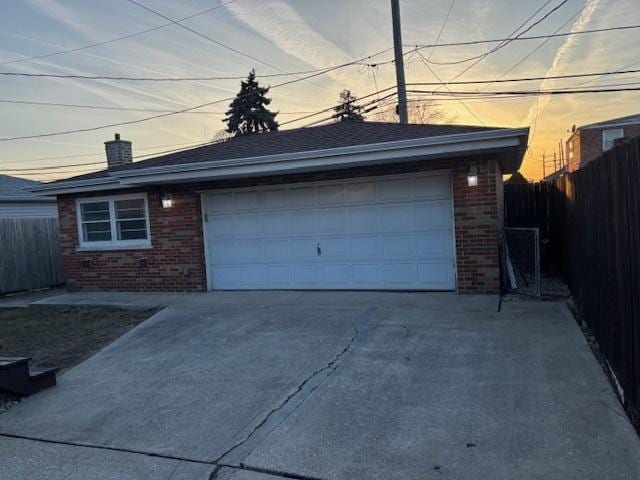 garage with concrete driveway and fence