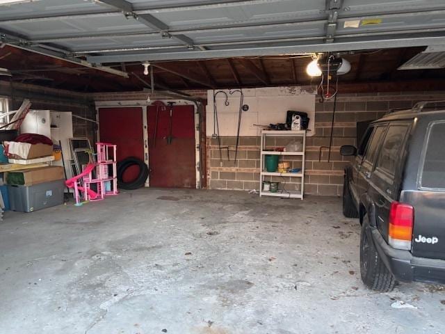 garage featuring a garage door opener and concrete block wall