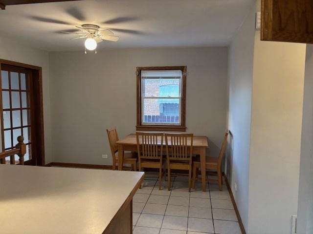 dining room featuring light tile patterned floors, baseboards, and a ceiling fan