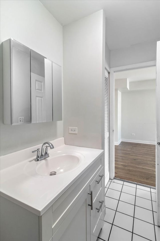 bathroom featuring tile patterned flooring, vanity, and baseboards