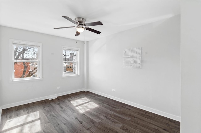 spare room with ceiling fan, baseboards, and dark wood-style floors