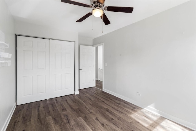 unfurnished bedroom with a ceiling fan, wood finished floors, a closet, and baseboards