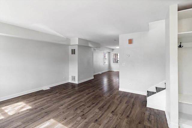 interior space with visible vents, stairs, baseboards, and dark wood-style flooring