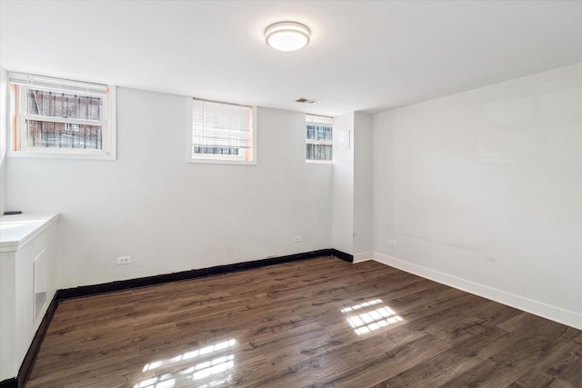 interior space featuring a wealth of natural light, baseboards, and dark wood-type flooring