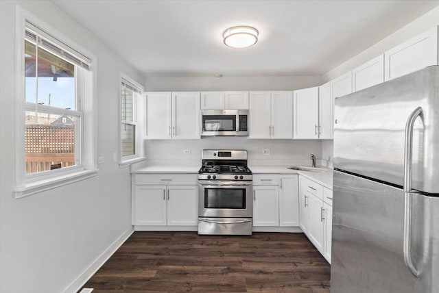 kitchen with white cabinetry, light countertops, appliances with stainless steel finishes, and a sink