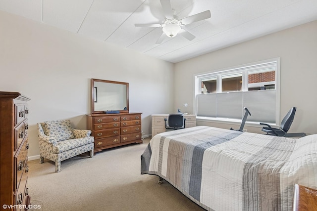 bedroom featuring light colored carpet, baseboards, and ceiling fan