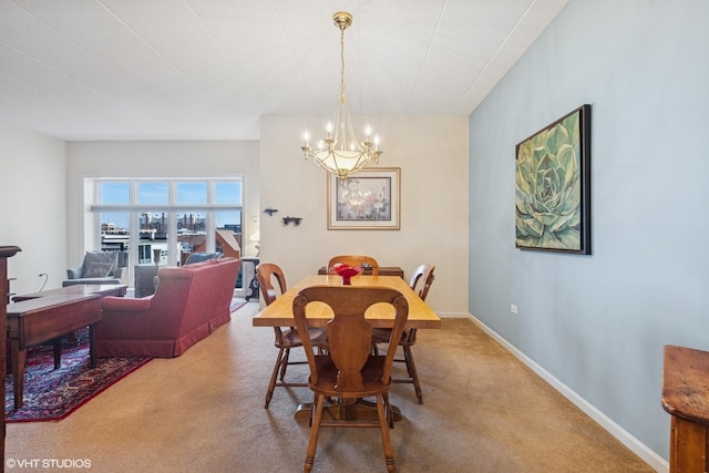 carpeted dining area featuring an inviting chandelier and baseboards