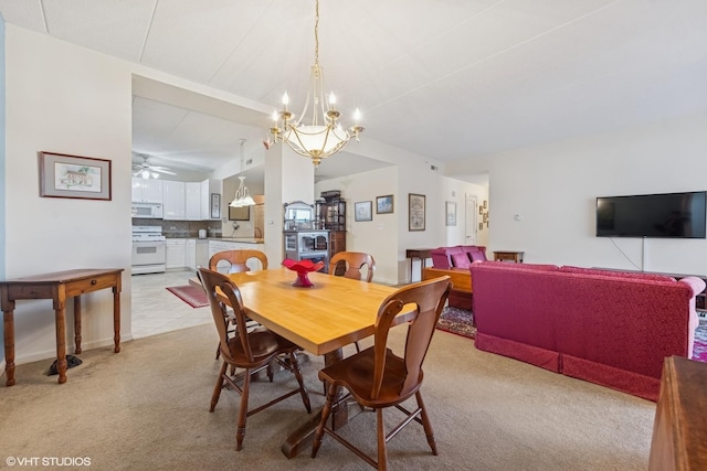 dining area with light colored carpet, ceiling fan with notable chandelier, and lofted ceiling