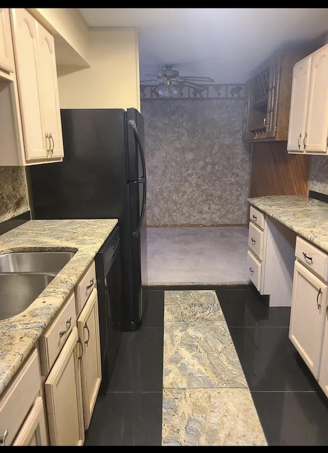 kitchen with white cabinetry, dark tile patterned floors, black dishwasher, and a ceiling fan