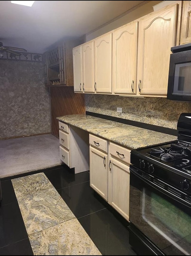 kitchen with white cabinets, black appliances, and dark tile patterned flooring