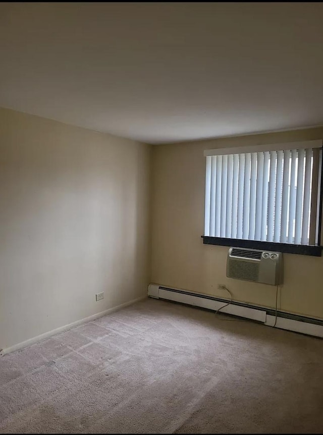 carpeted spare room featuring a wall mounted air conditioner, a baseboard radiator, and baseboards