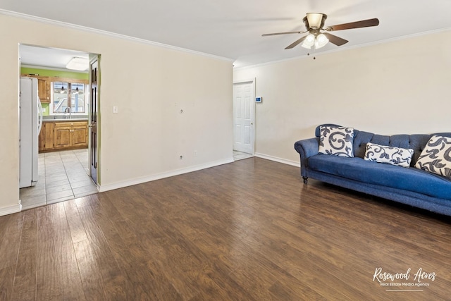 495 Water Tower Rd S, Manteno, IL 60950 - unfurnished living room featuring wood-type flooring, ornamental molding, baseboards, a sink, and ceiling fan