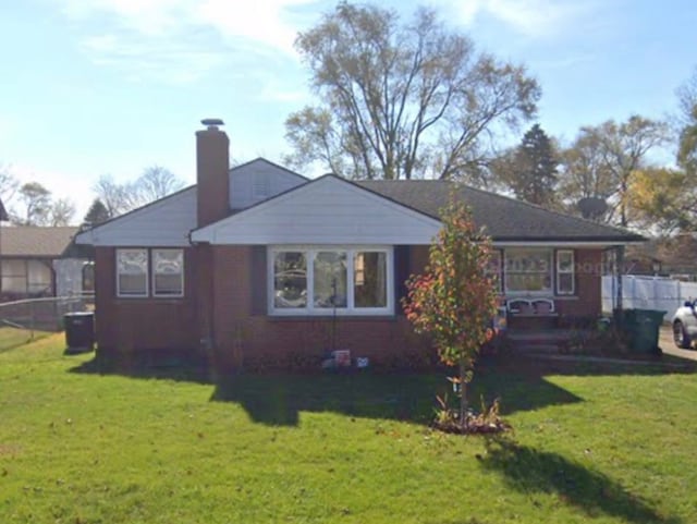 back of property featuring a yard, fence, and a chimney