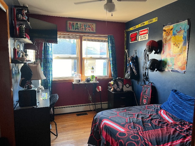 bedroom featuring a baseboard radiator, a ceiling fan, and wood finished floors