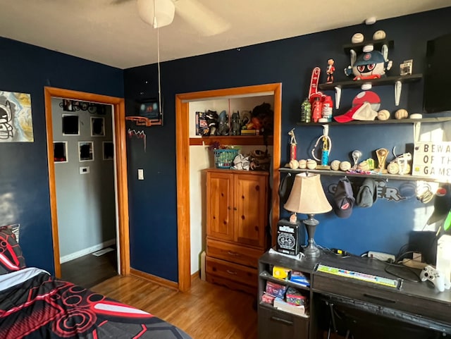 bedroom with a closet, baseboards, and wood finished floors