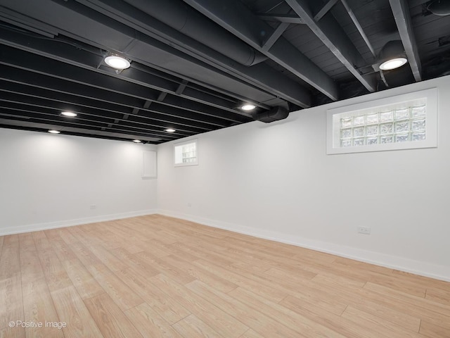 below grade area with baseboards and wood finished floors