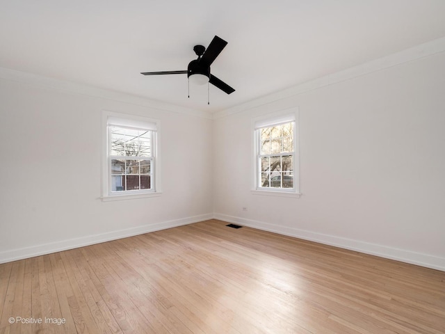 unfurnished room with light wood finished floors, a healthy amount of sunlight, and crown molding