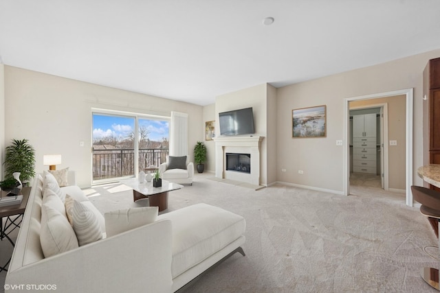 living room featuring a fireplace with flush hearth, light colored carpet, and baseboards