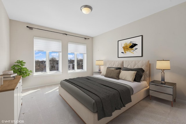 bedroom with light colored carpet and baseboards